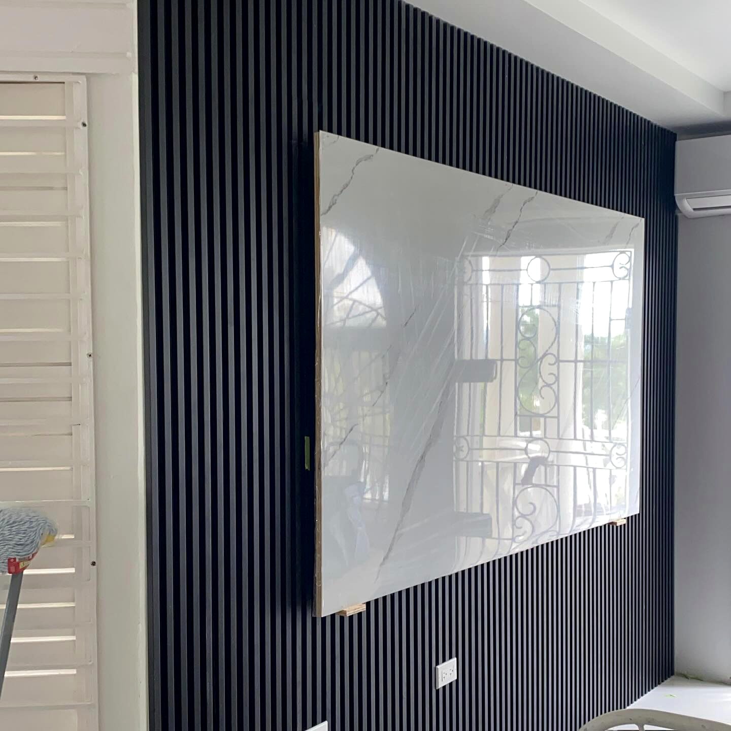 TV Ready White Marble Sheet installed with Black Fluted PVC
